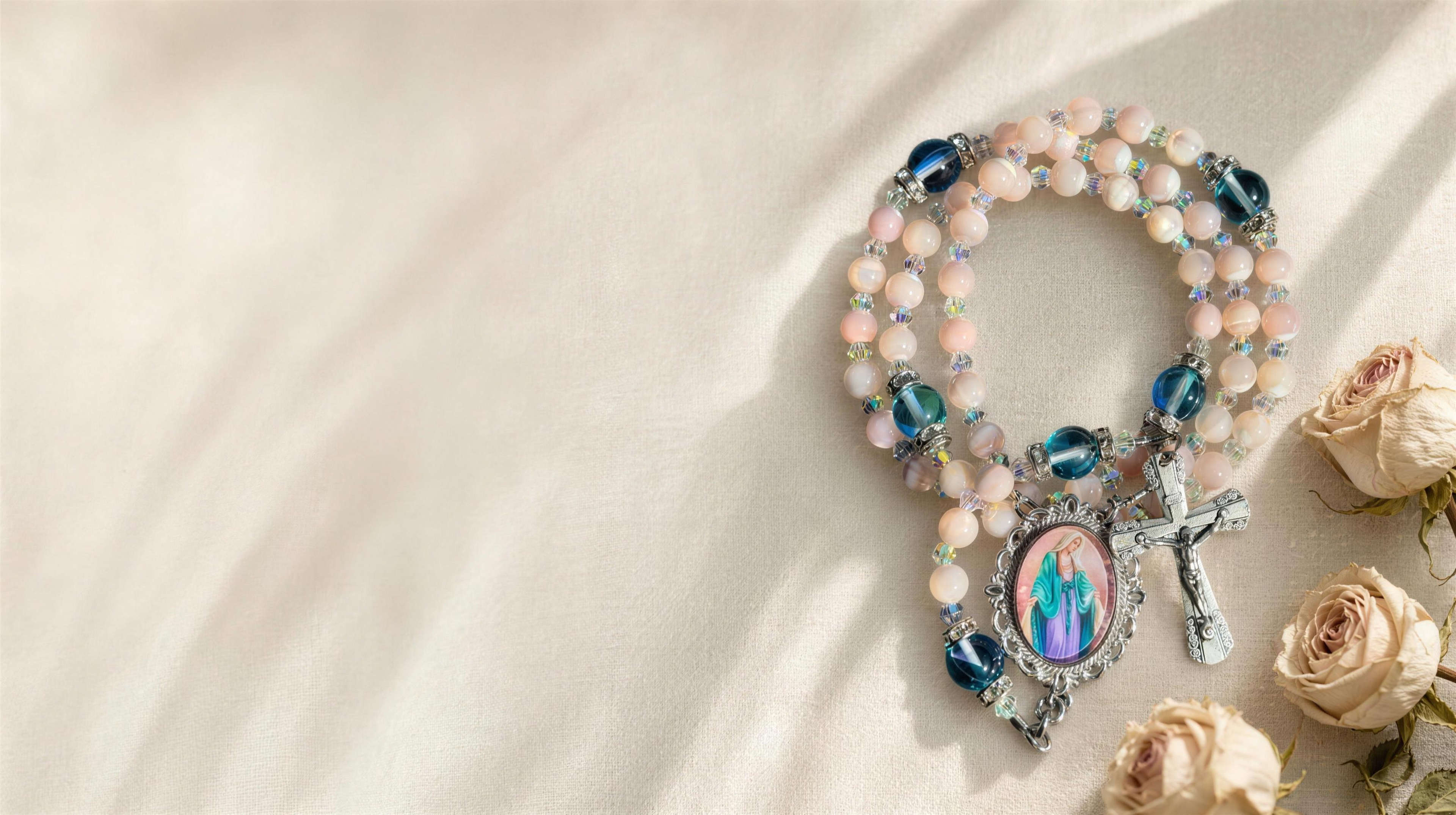 A handmade gemstone rosary with a Marian medallion resting on ivory linen in soft light